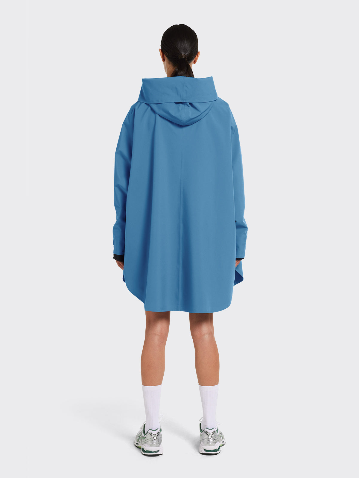 Woman dressed in Bergen poncho from Blæst in Coronet Blue