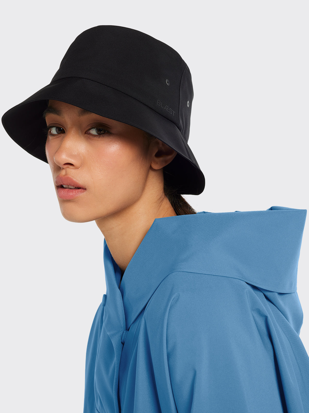 Woman dressed in Bergen poncho and Bucket hat from Blæst