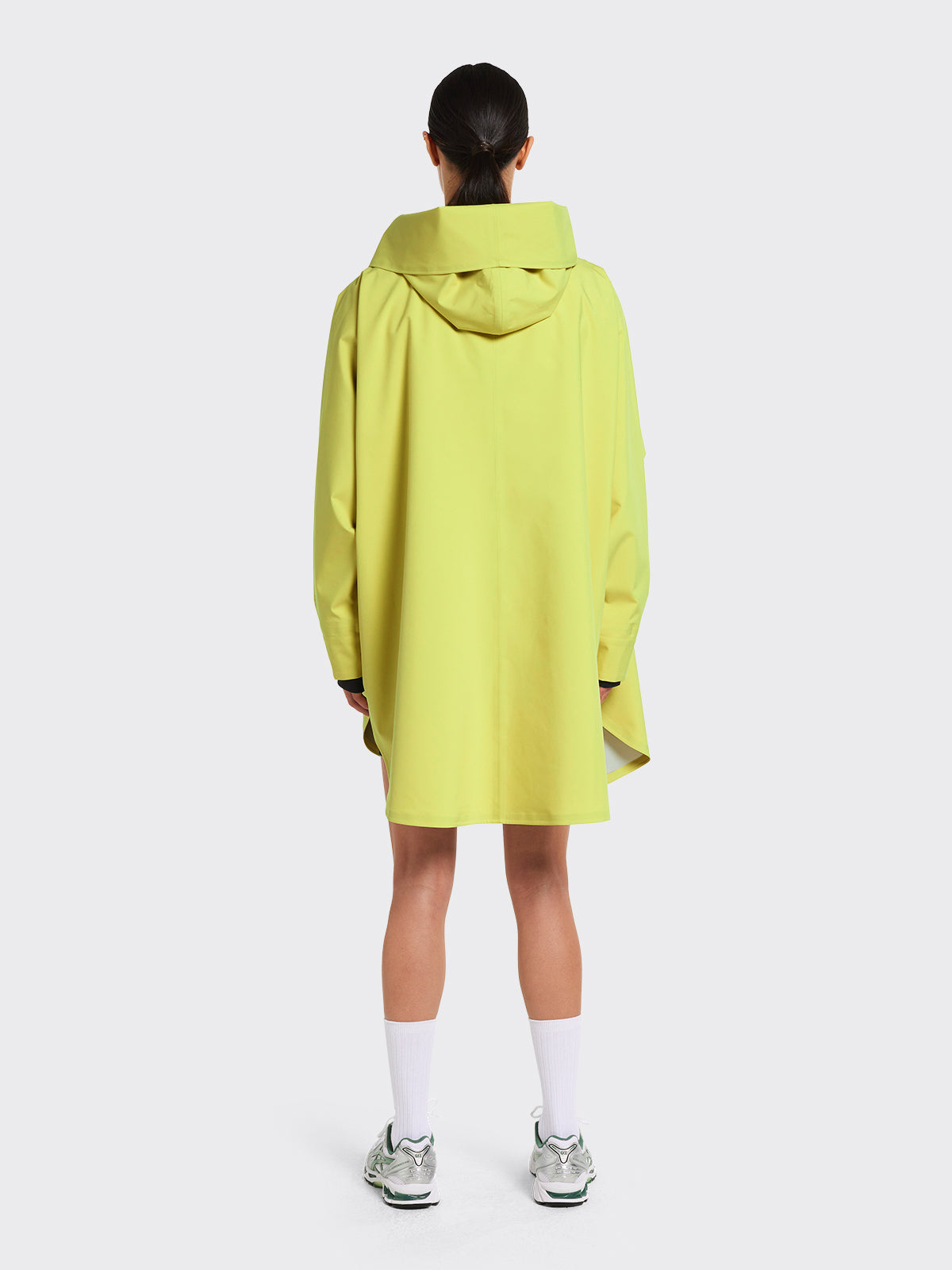 Woman wearing Bergen poncho in the color Muted Lime from Blæst