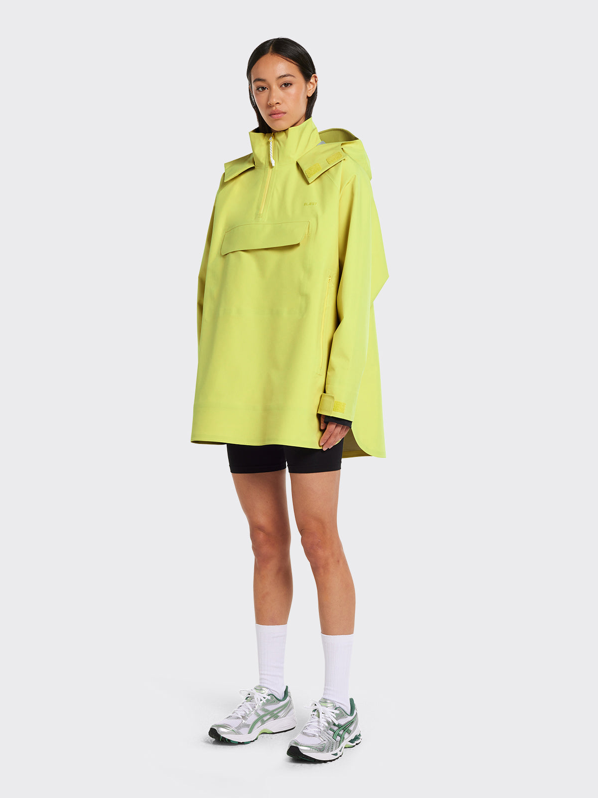 Woman dressed in Voss poncho by Blæst in Muted Lime