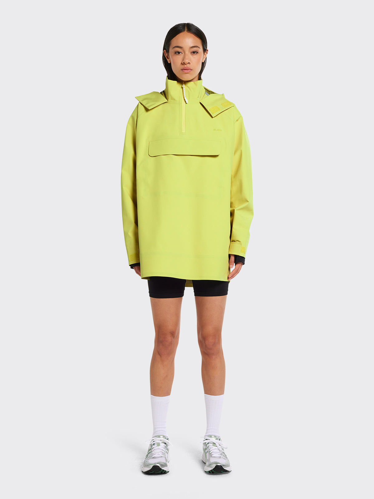 Woman in Voss poncho from Blæst in the color Muted Lime