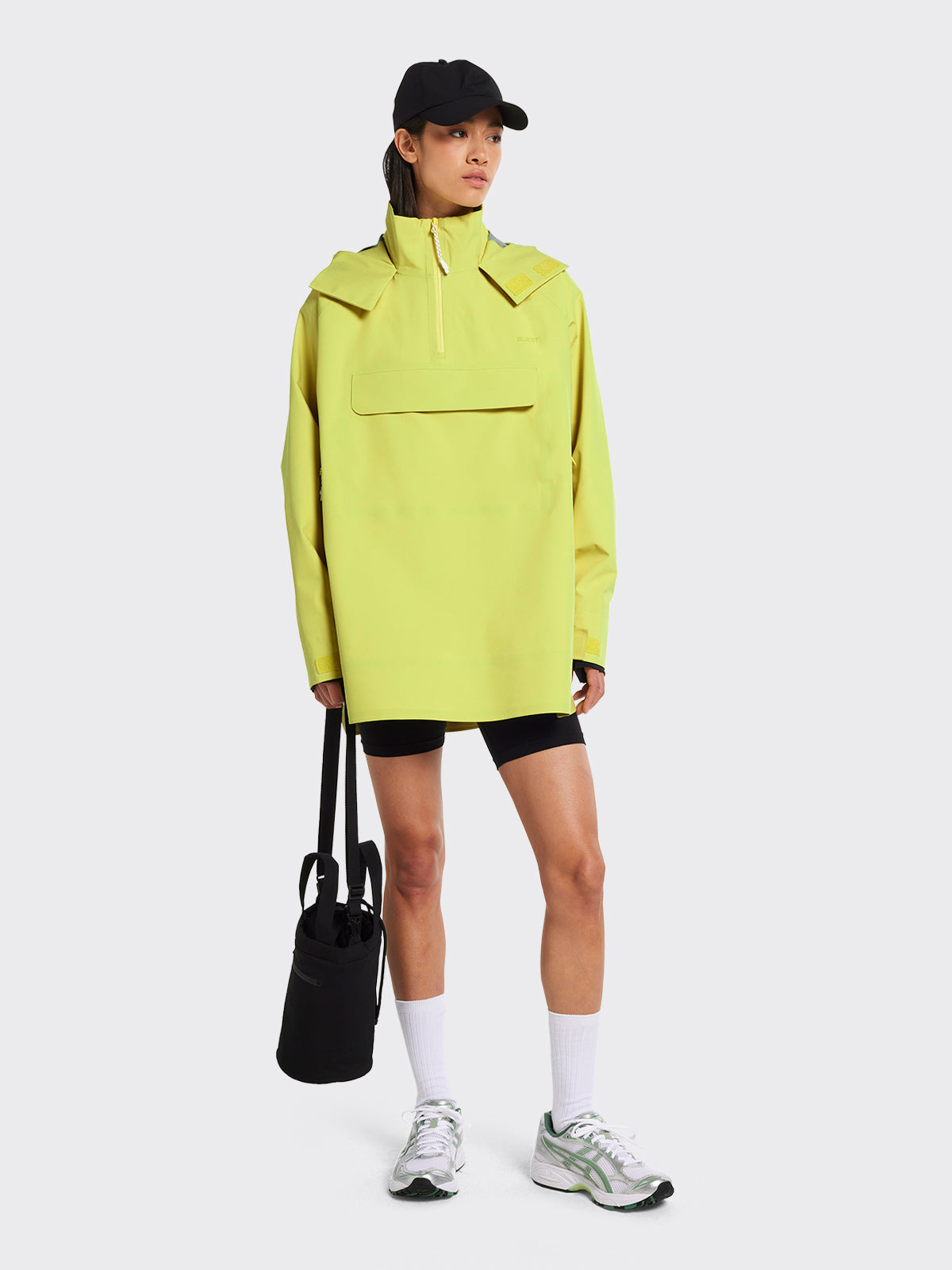 Woman dressed in Voss poncho in the color Muted Lime by Blæst
